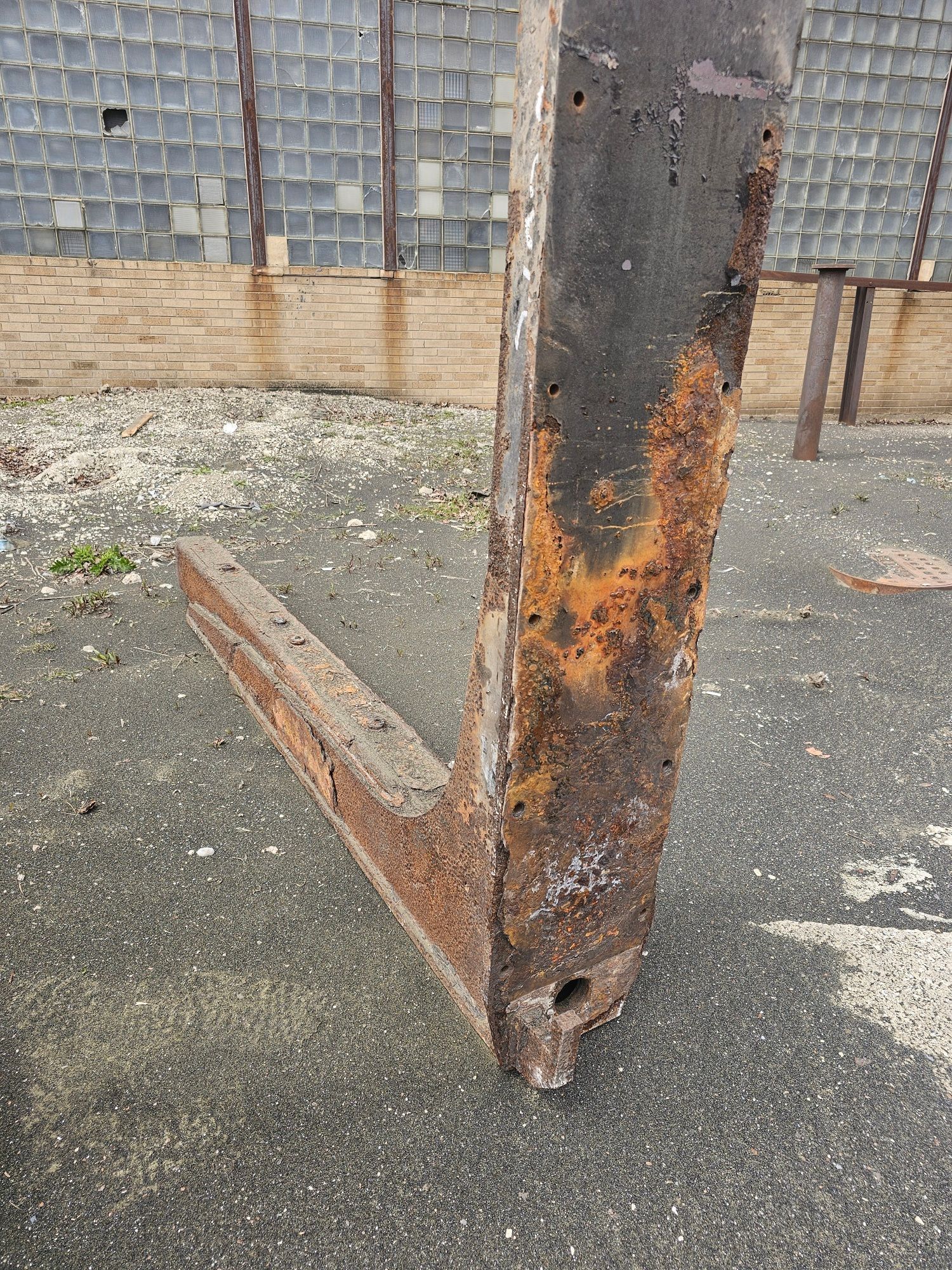 A rusty piece of metal is sitting on the ground