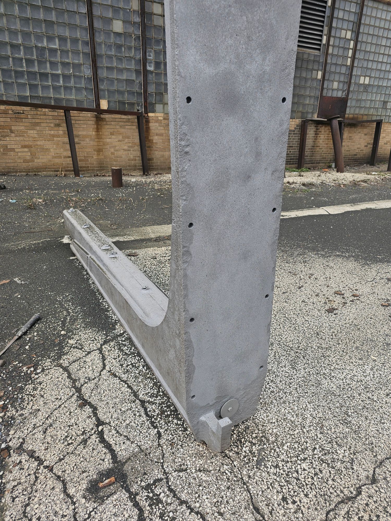 A piece of concrete sits on the ground in front of a building.