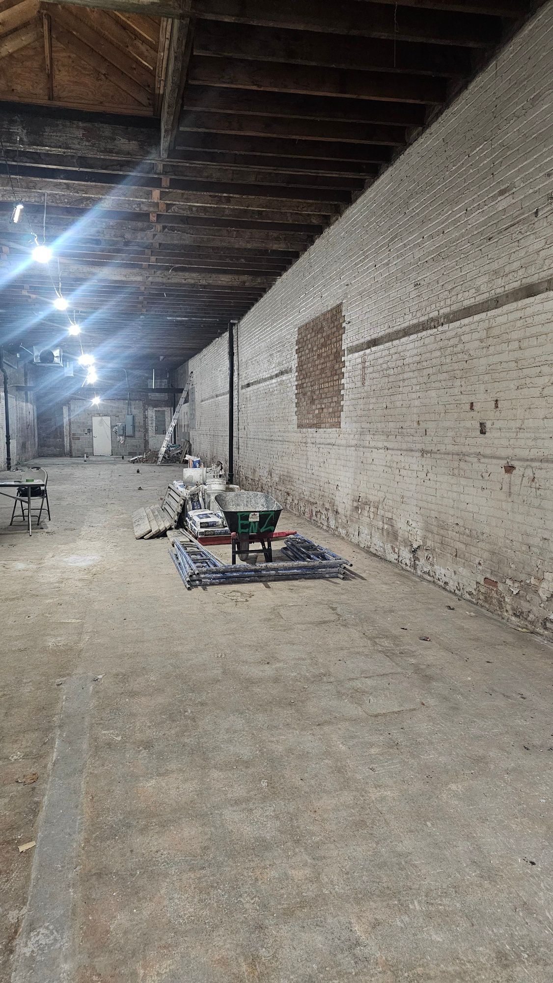 A large warehouse with a wheelbarrow in the middle of it.