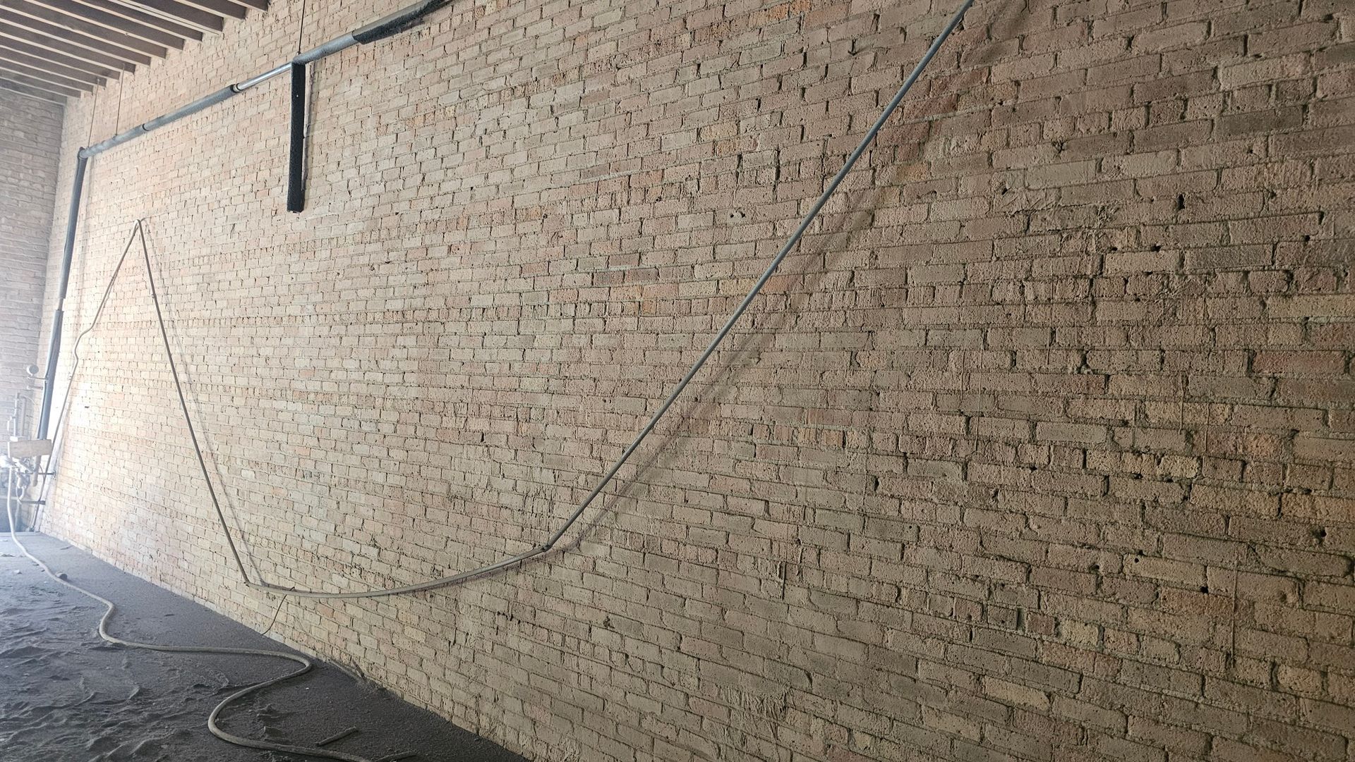 A large brick wall with a lot of wires hanging from it.