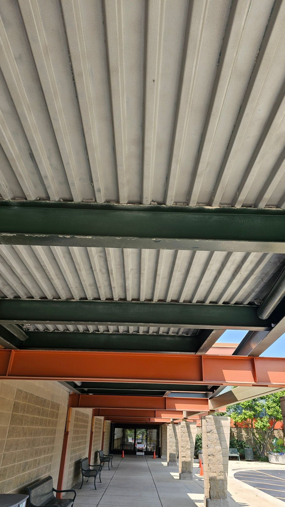 Looking up at the ceiling of a building with a covered walkway.