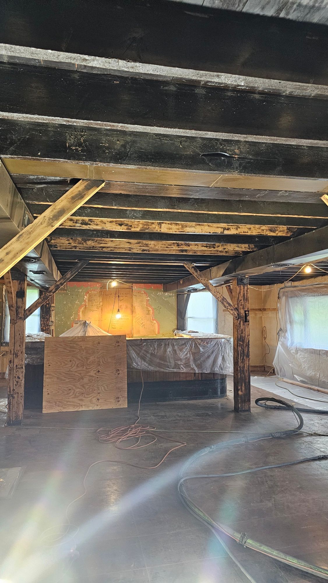 A large empty room with wooden beams and a couch.