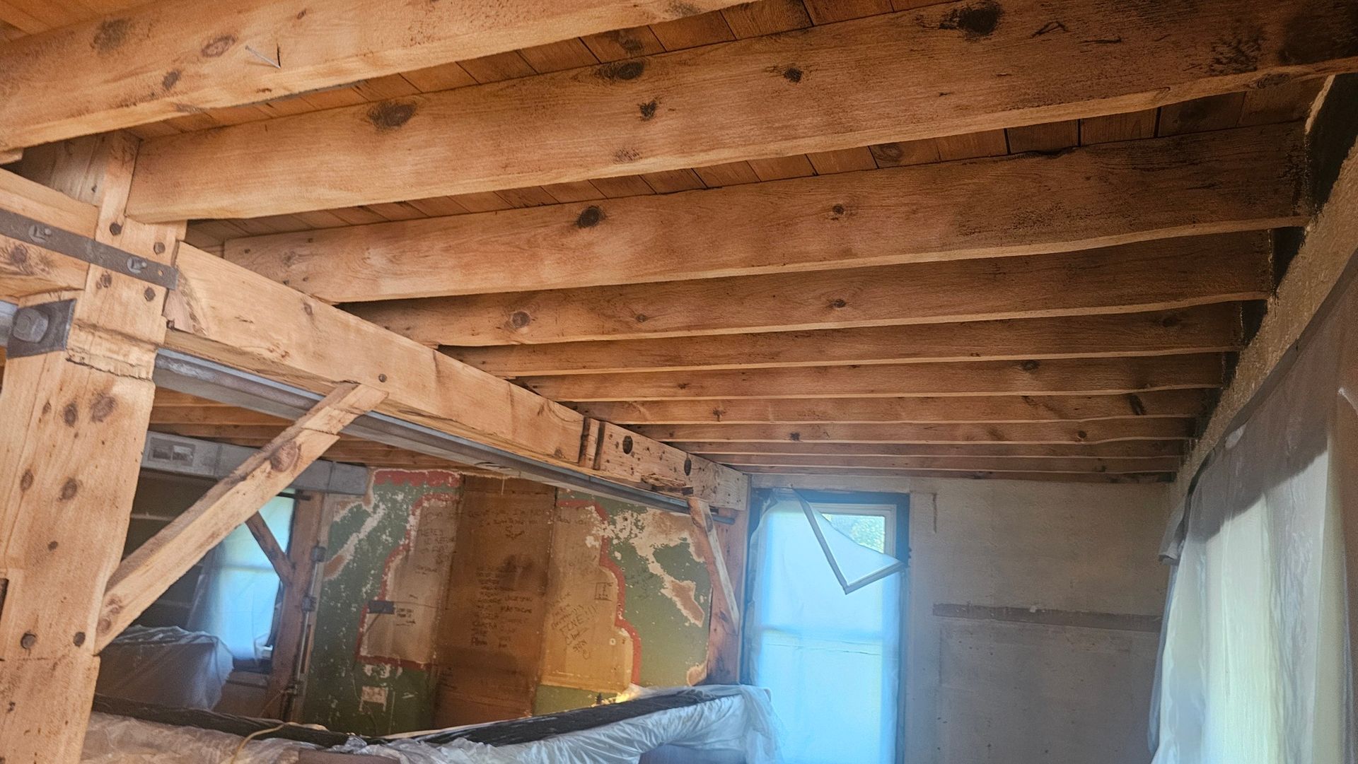 A room with a wooden ceiling and a window.