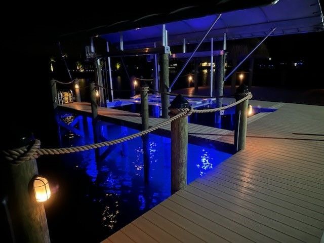 A red and white boat is docked at a dock in the water