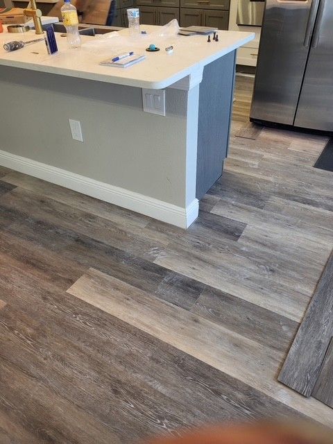 Empty room with white marble-look floor and white walls. Chandelier hangs from ceiling.