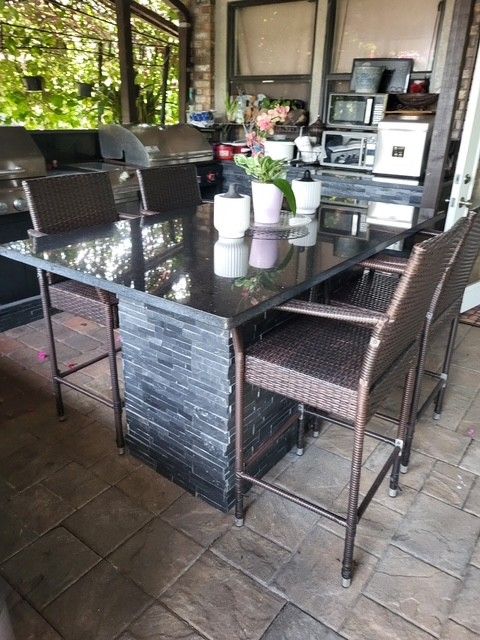 Kitchen with white countertop, cabinets, and island, stainless steel appliances, dark wood floors.