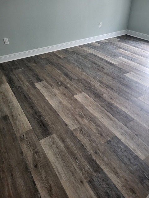 gray and tan wood-look plank flooring in a room with white trim and light blue walls