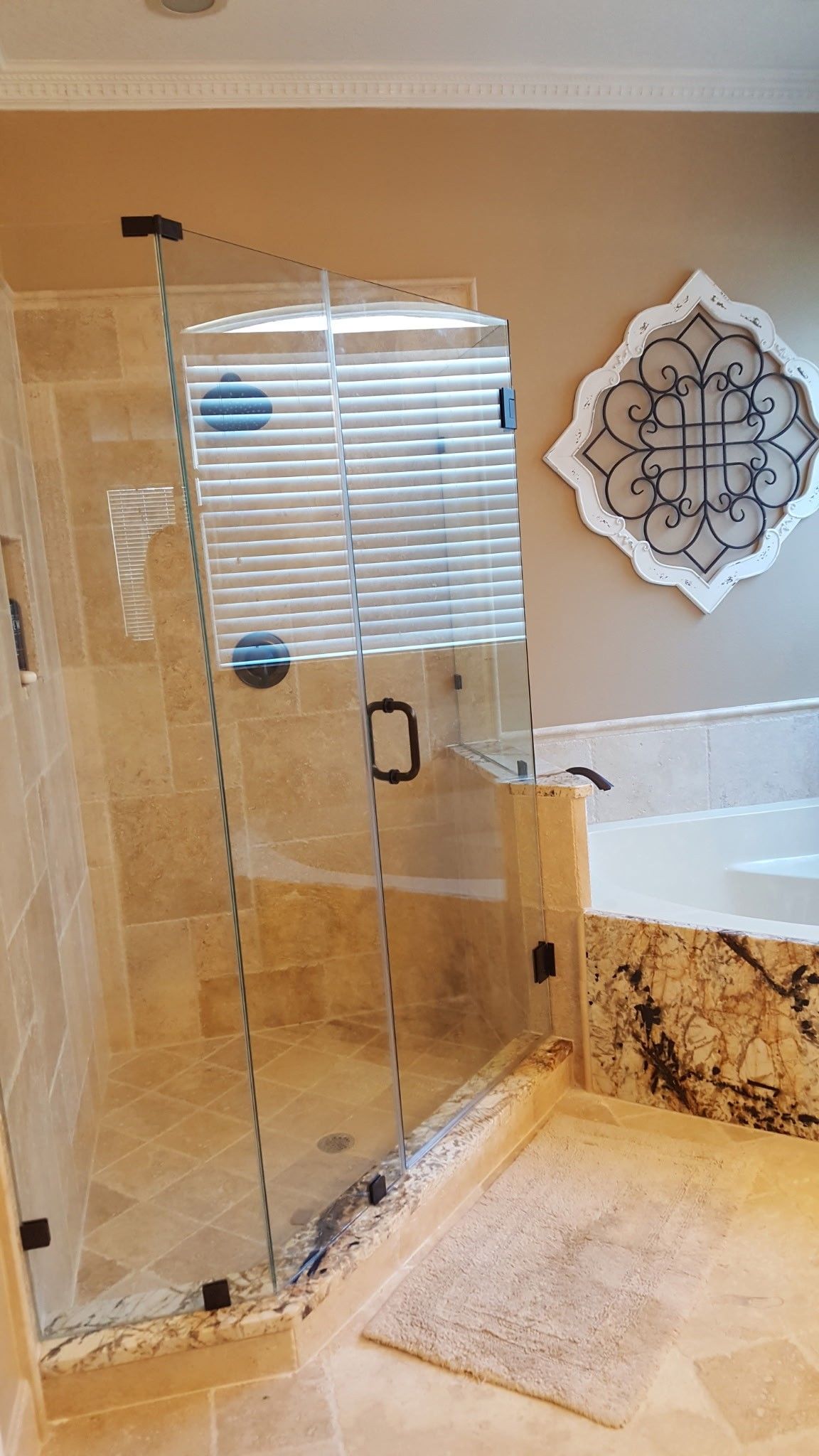 a luxurious bathroom with a glass shower enclosure and a decorative wall art piece