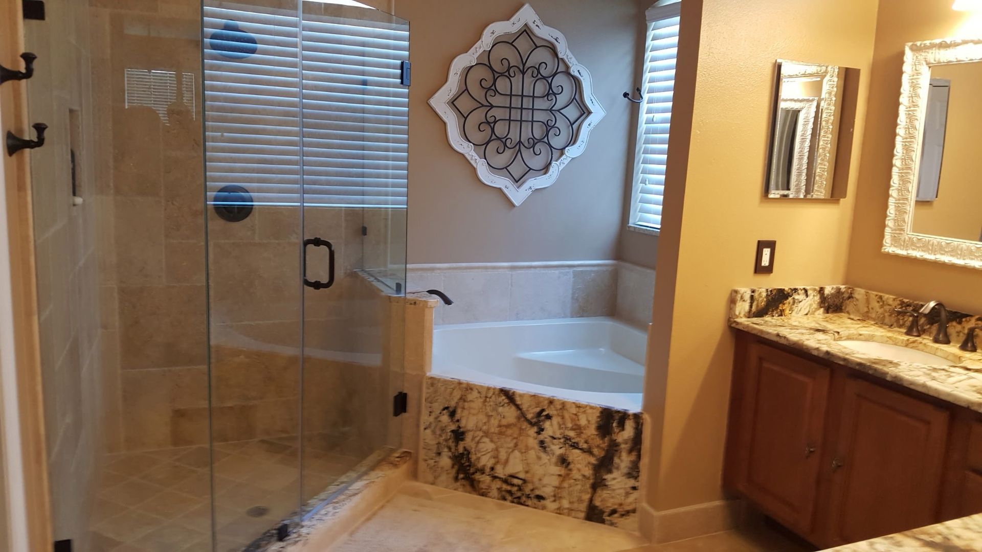 bathroom with glass shower, jacuzzi tub, granite countertop vanity, and decorative wall art