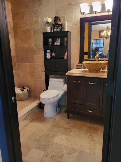 bathroom with brown vanity, toilet, and cabinet