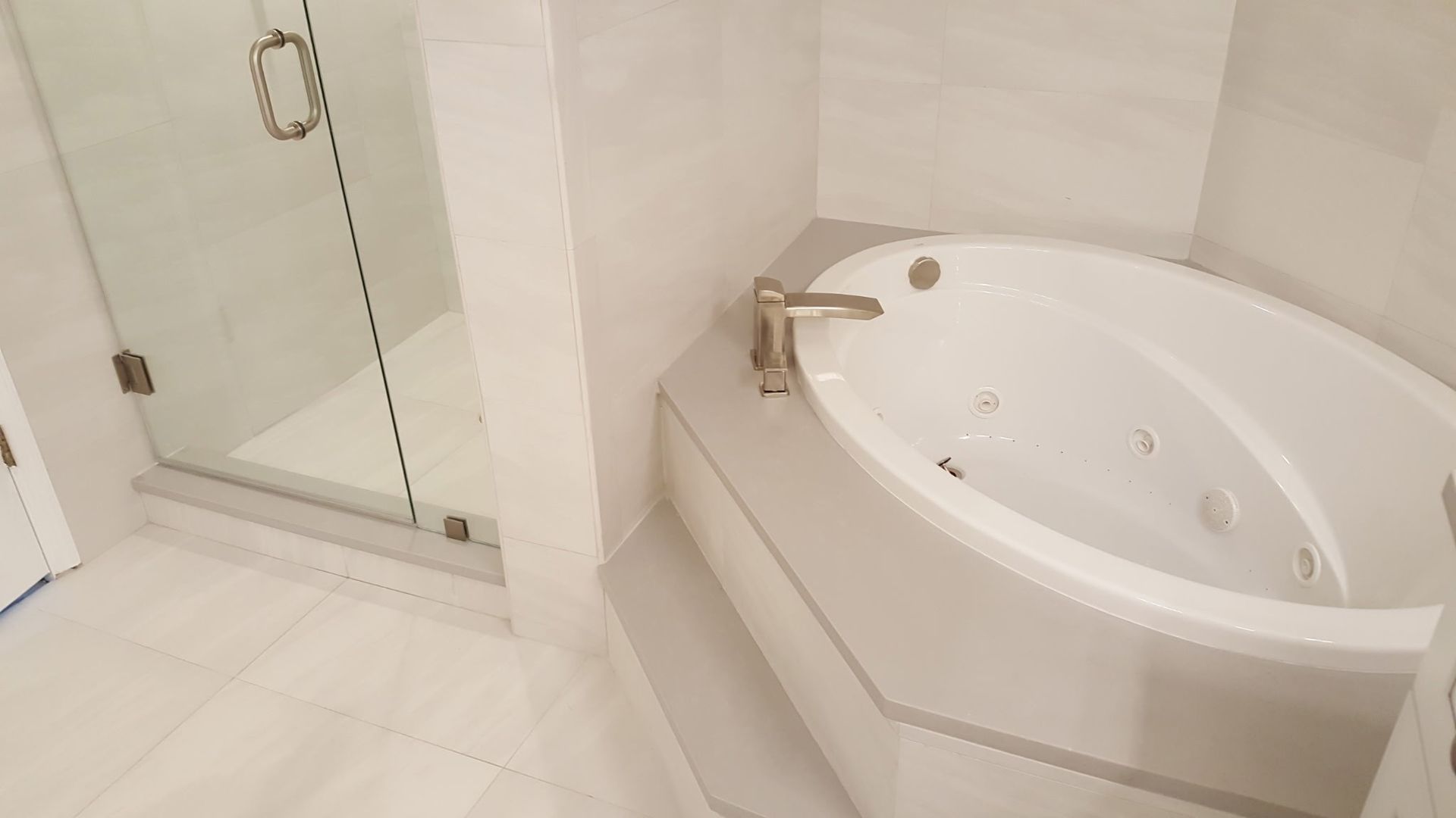white bathroom with a jacuzzi tub and glass shower