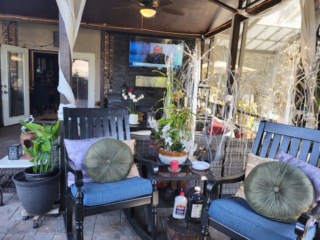 outdoor patio with seating, TV, plants, and decorations