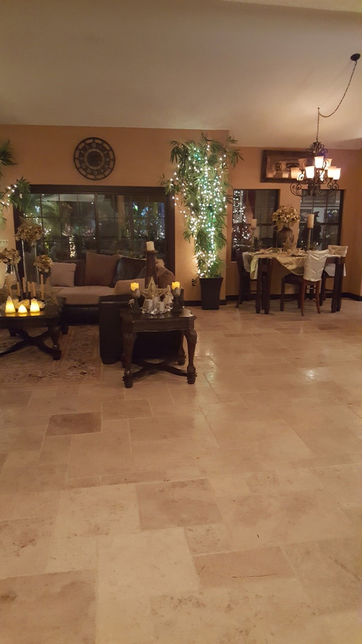 Living room decorated with candles, fairy lights, and a dining table; warm lighting.