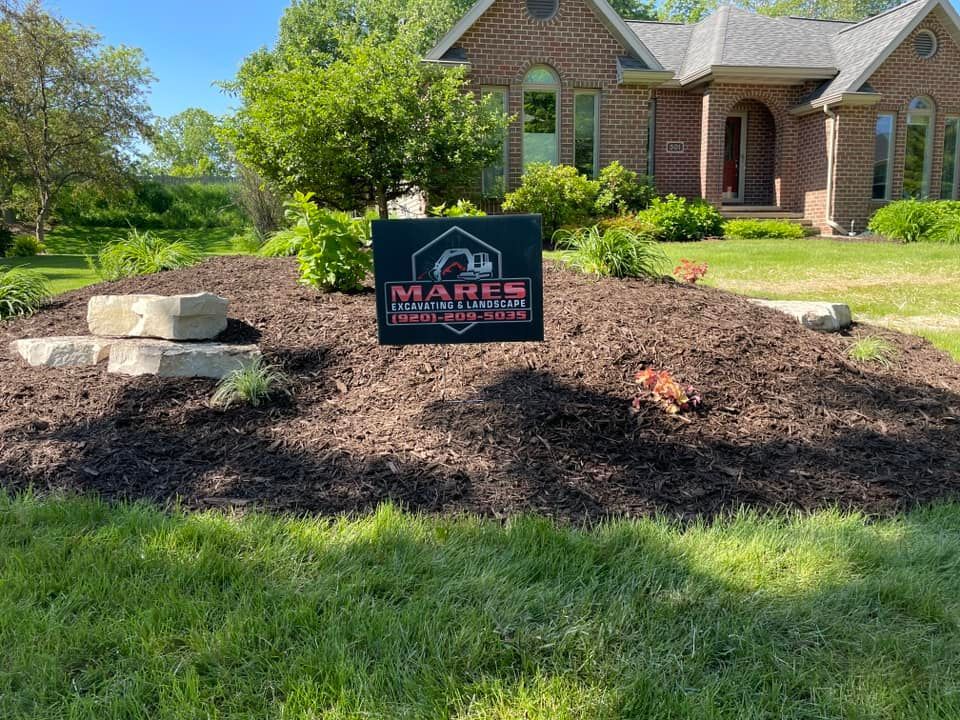 A large brick house with a sign in front of it.