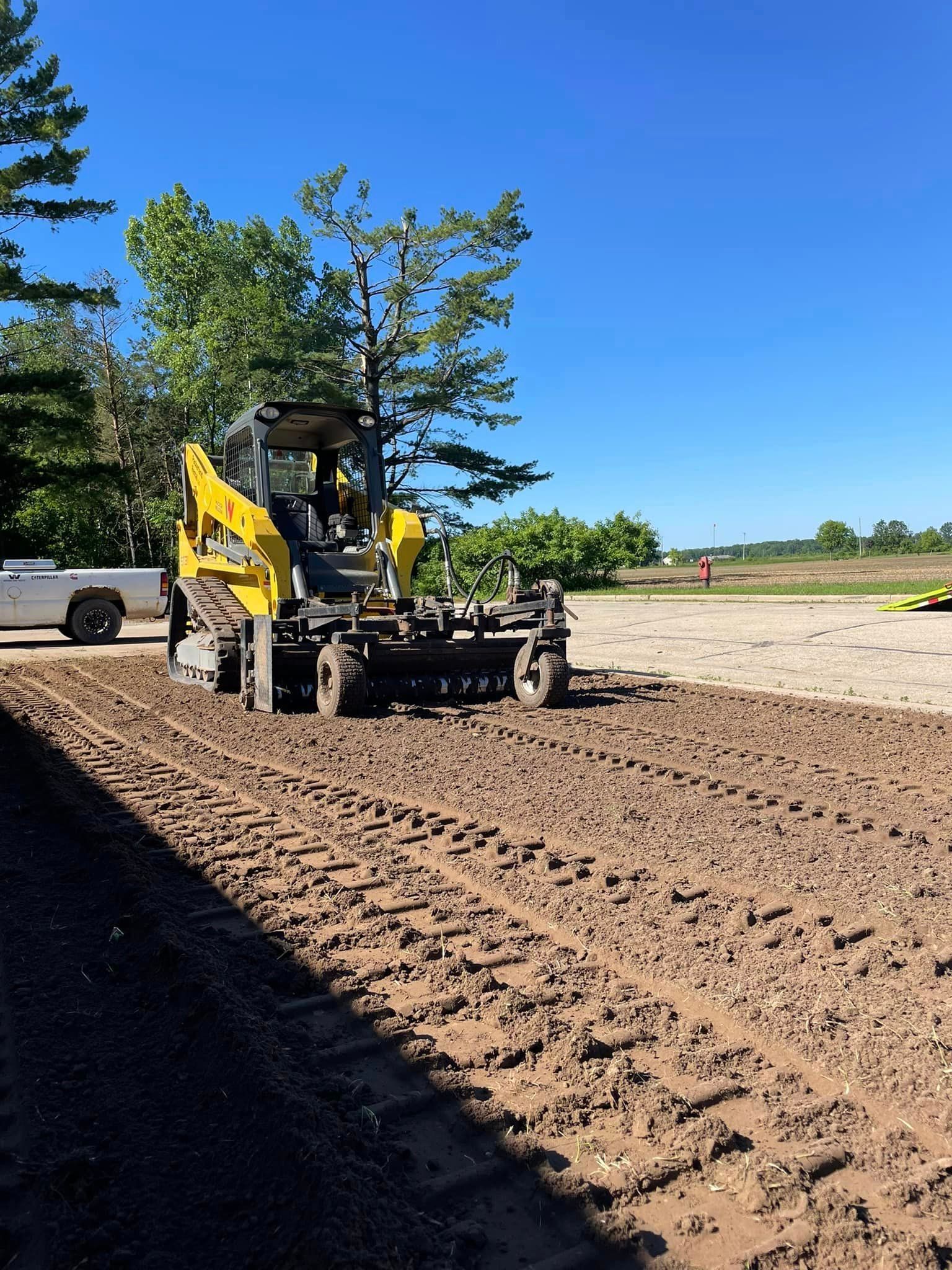 A yellow bulldozer is moving dirt in a dirt field.