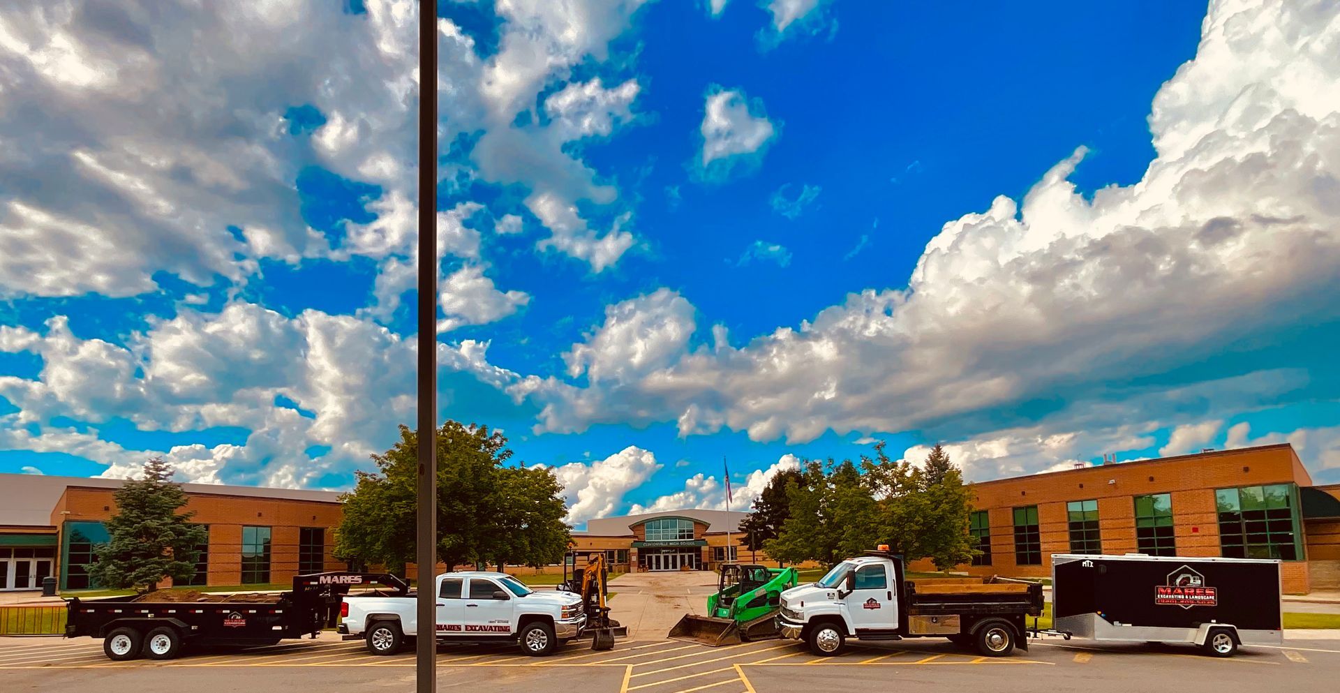 A row of trucks parked in front of a building on a cloudy day.