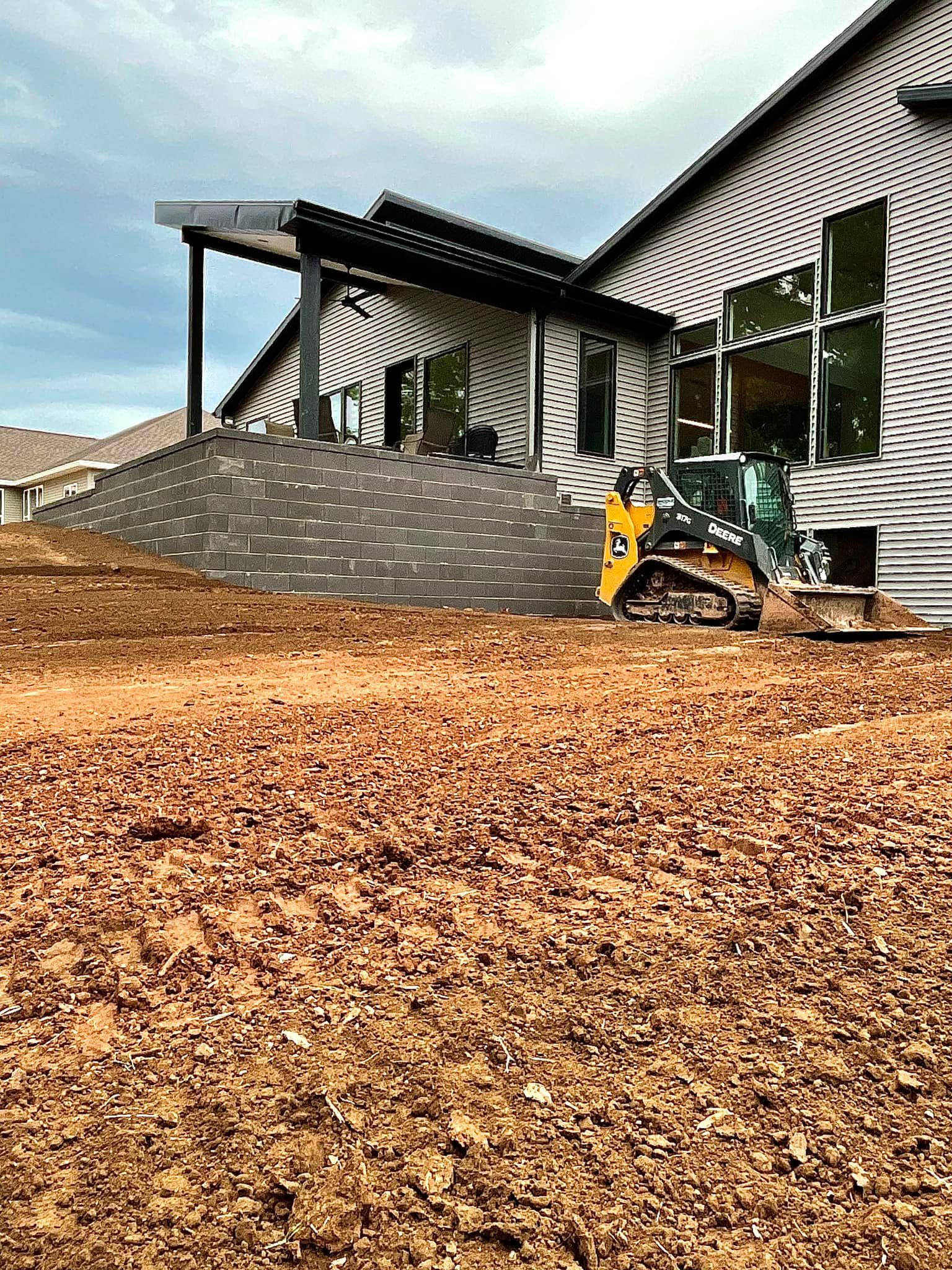 A bulldozer is sitting in front of a house.