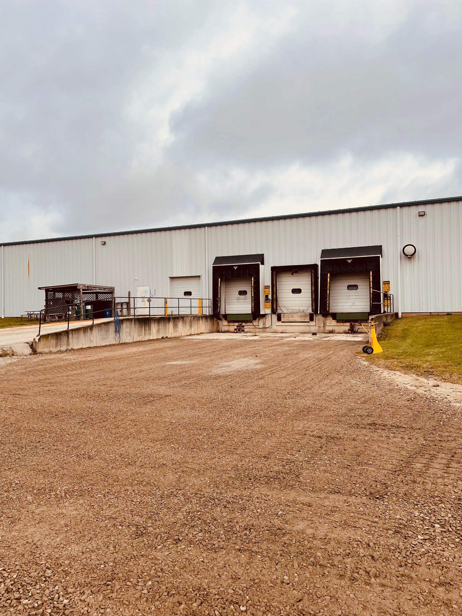 A large white building with a lot of loading docks in front of it.