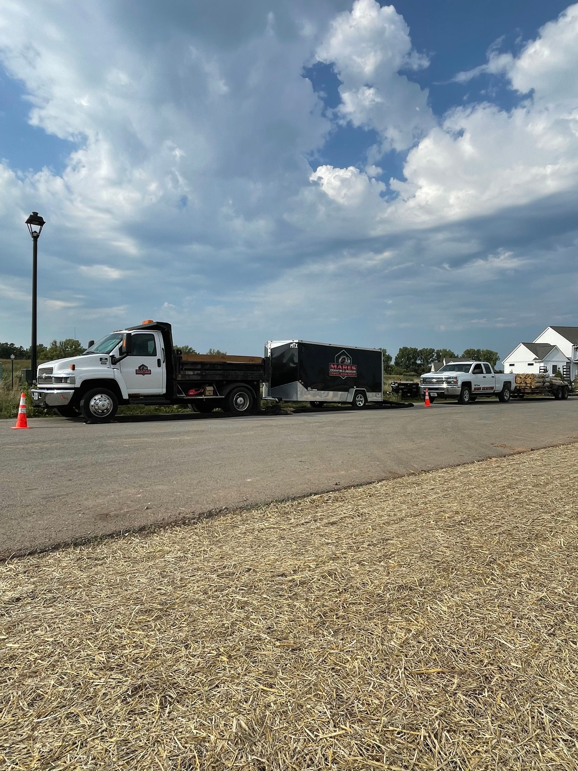 A row of trucks are parked on the side of the road.
