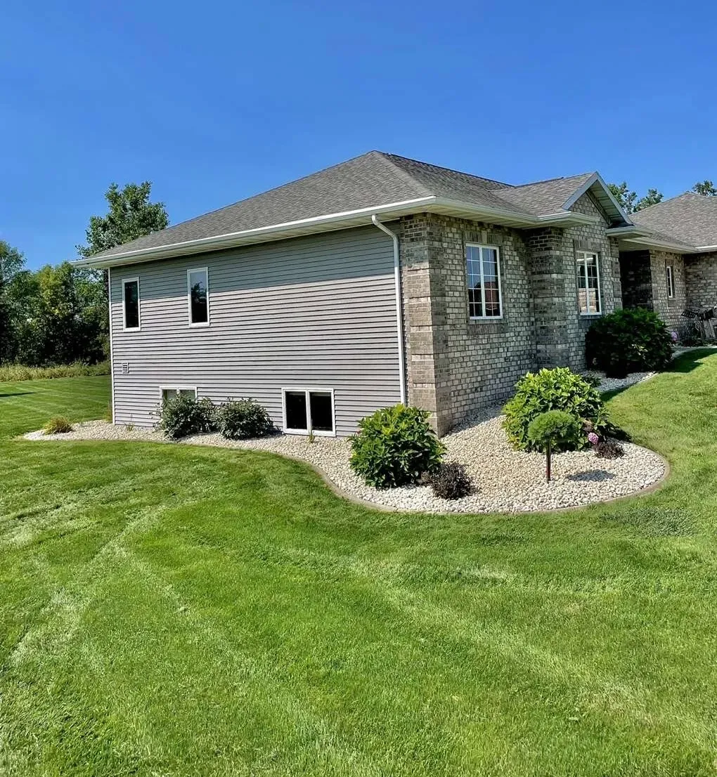 A house with a large lawn in front of it.