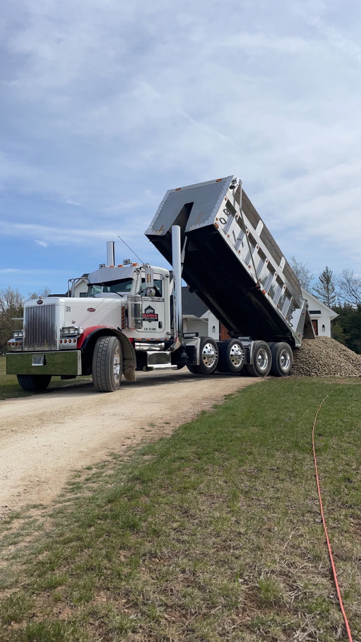 A dump truck is driving down a dirt road.