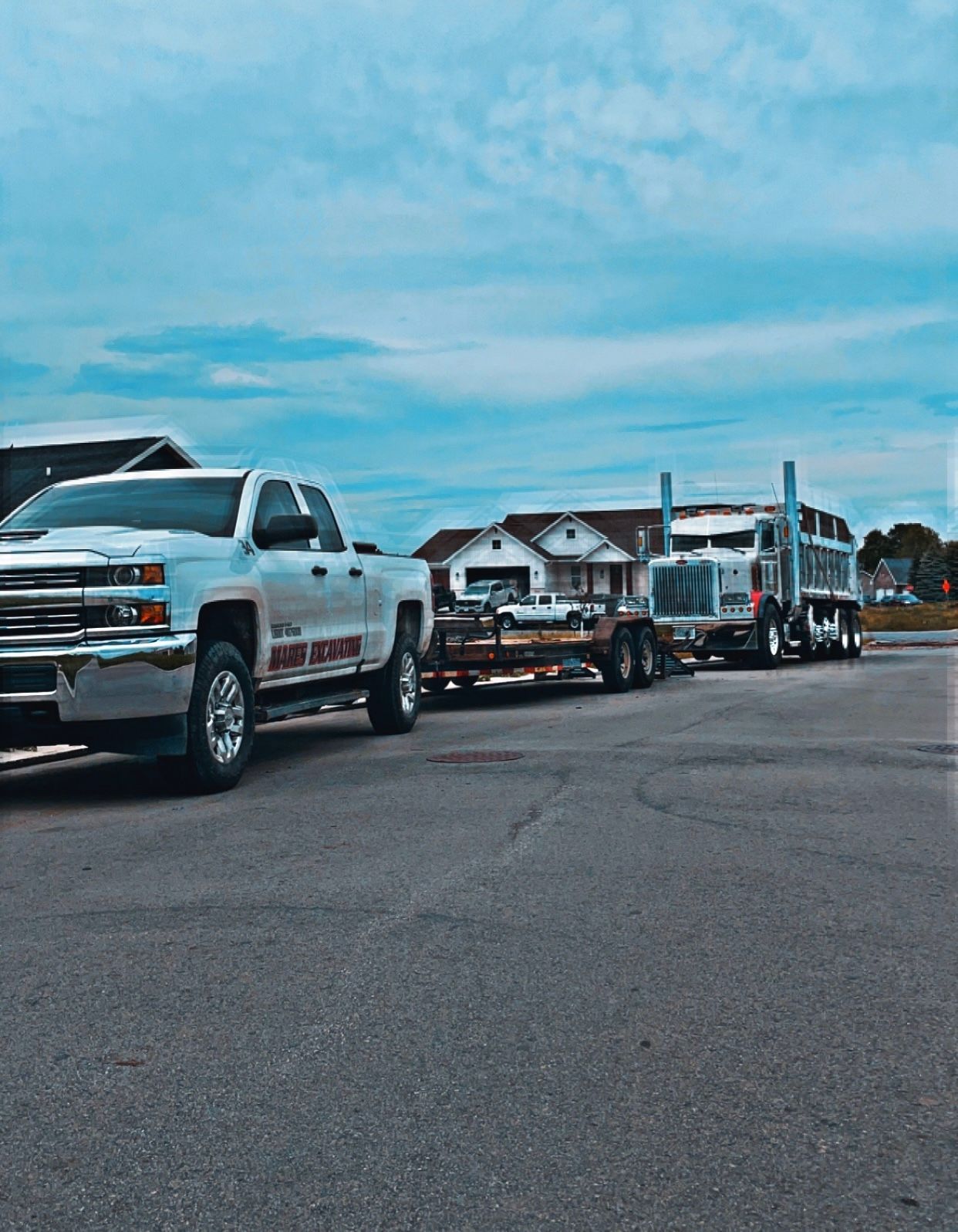 A row of trucks are parked on the side of the road.