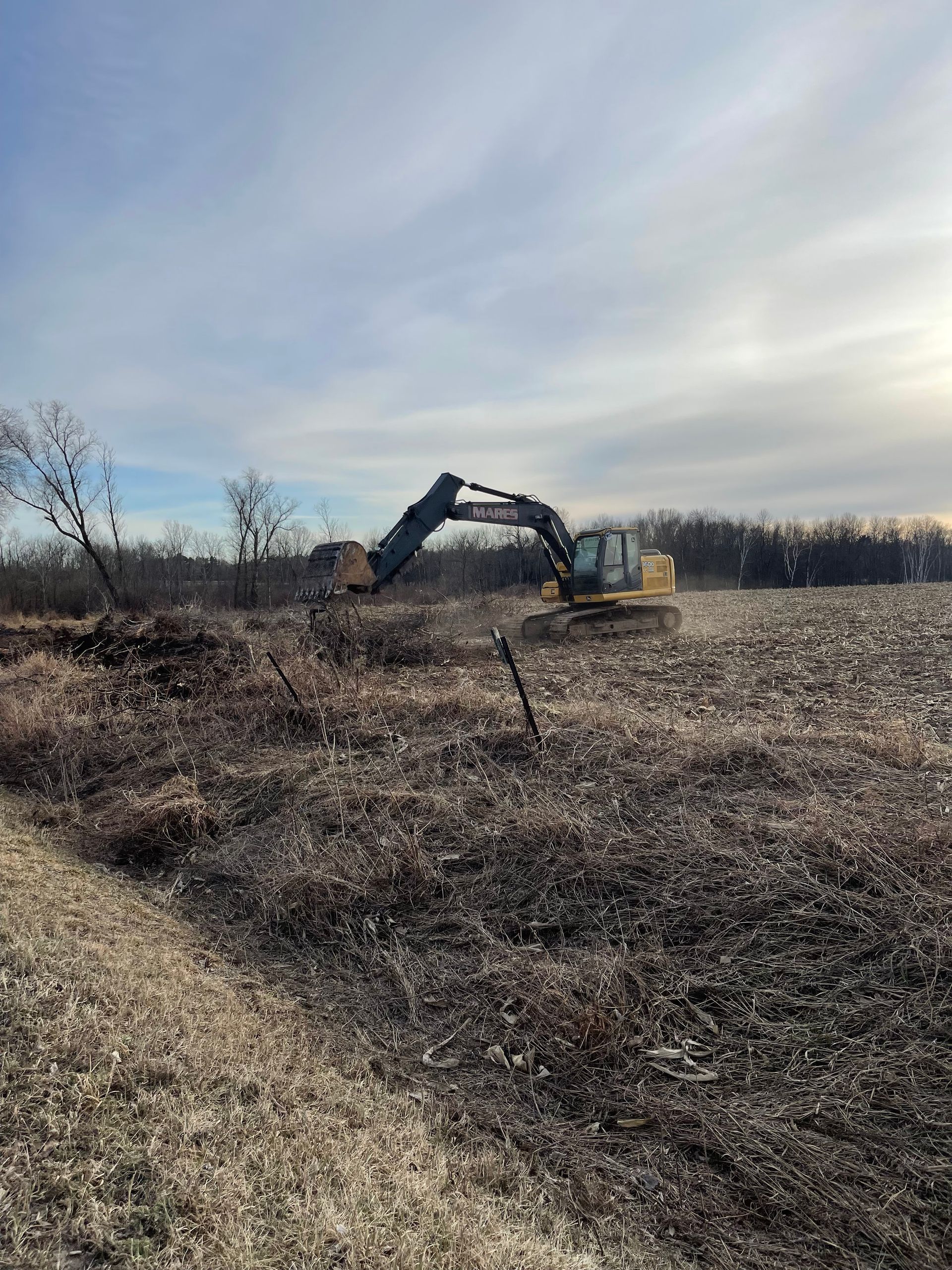 A large excavator is working in a field.