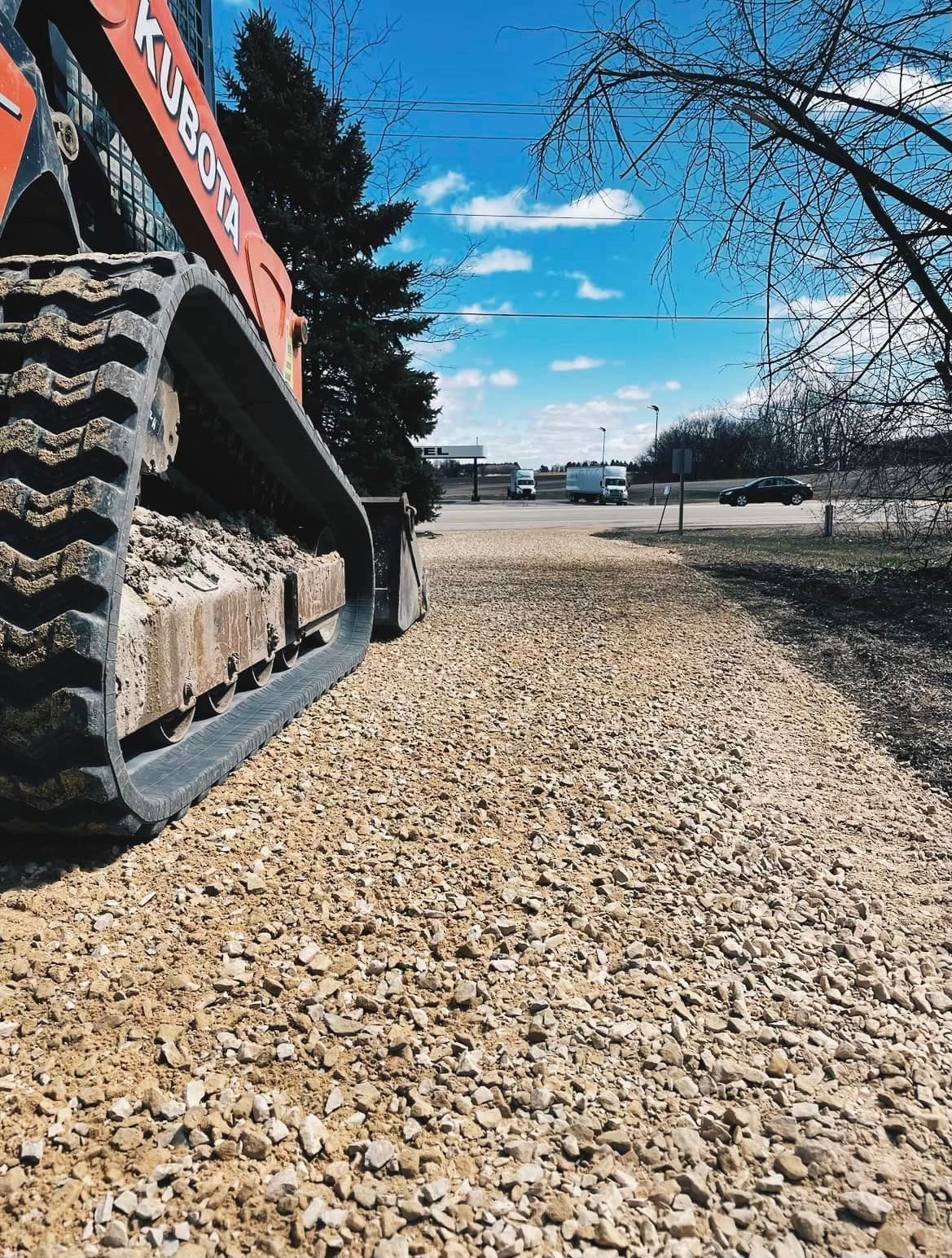 A bulldozer is parked on a gravel road.