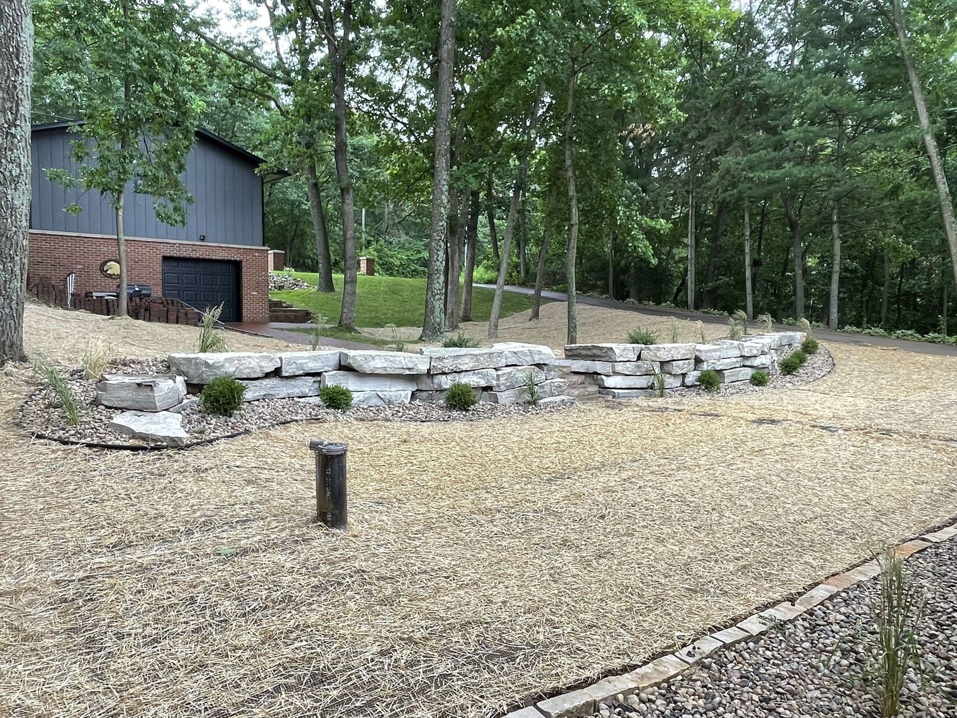There is a large rock wall in the middle of the yard.