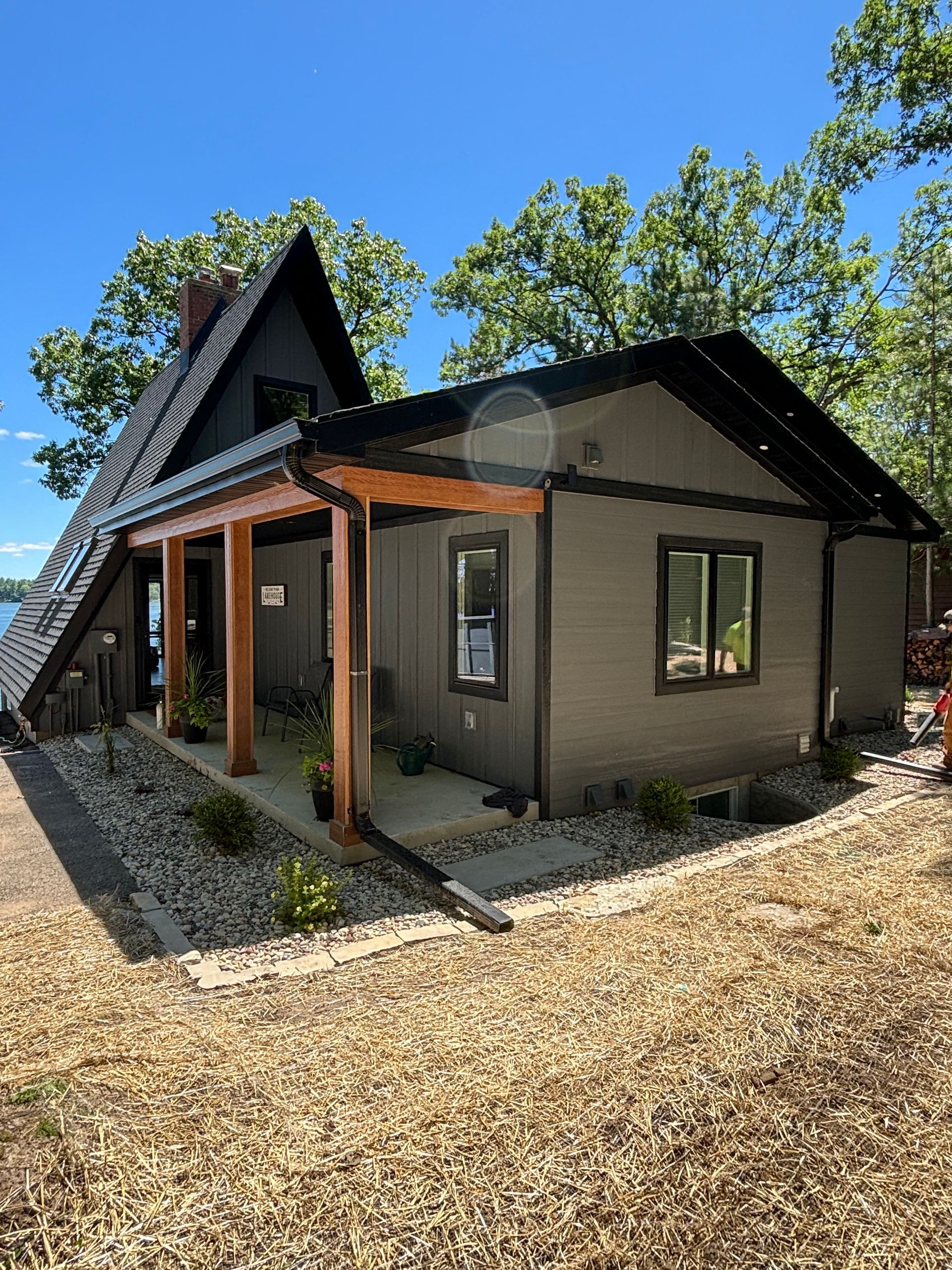 A small house with a porch and a lot of windows.