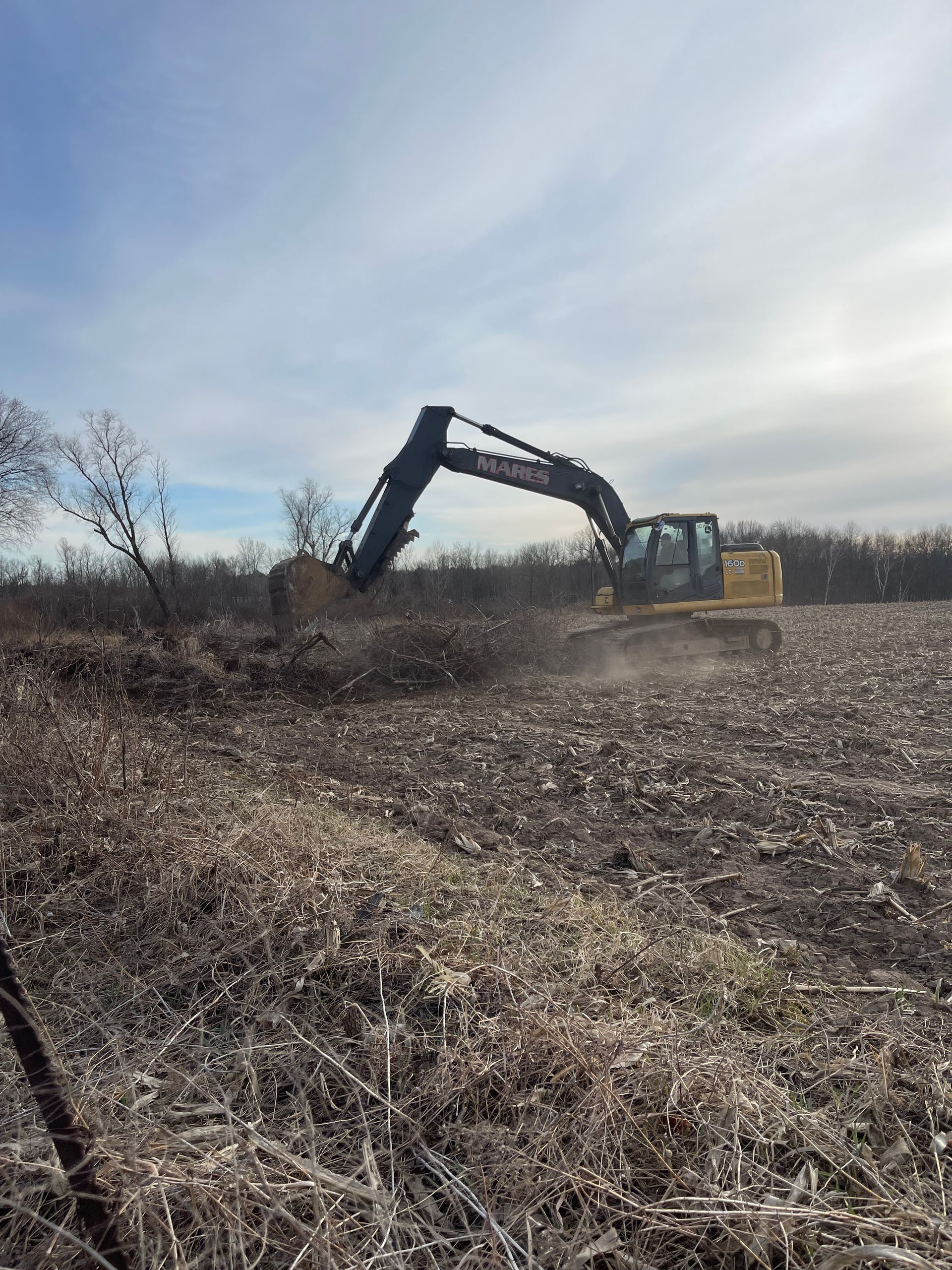 A large excavator is working in a field.