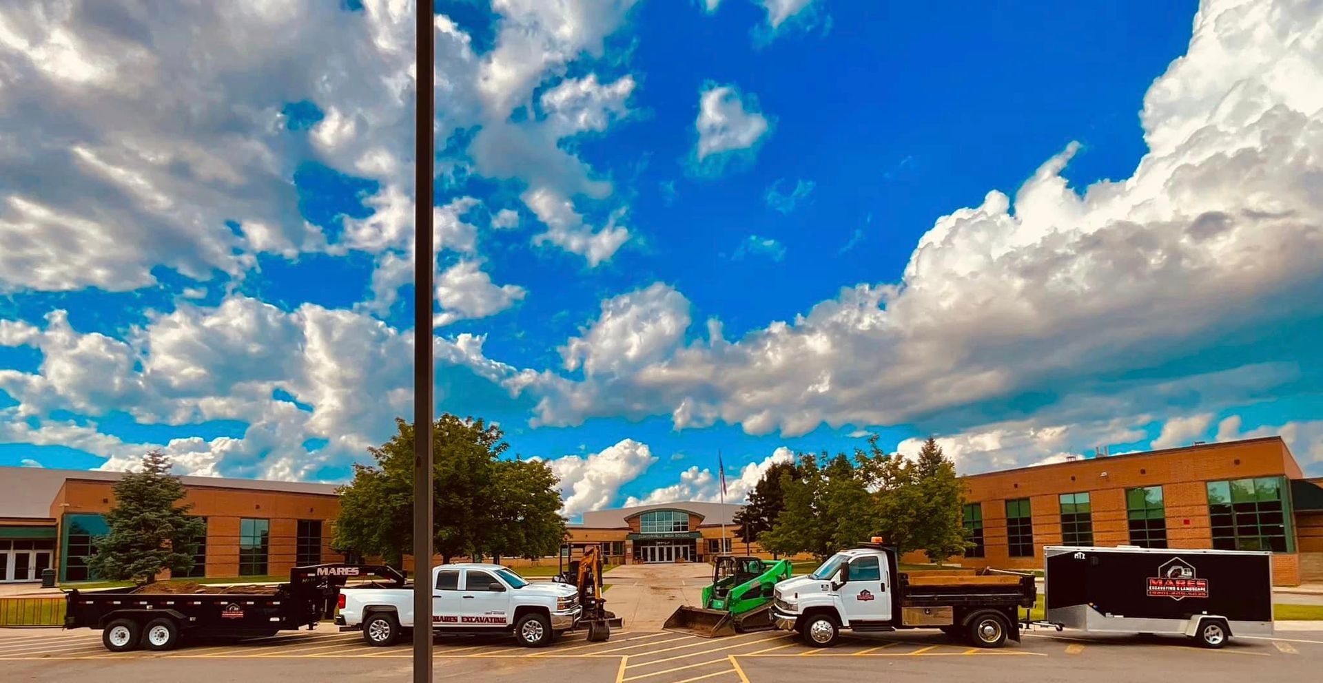 A row of trucks parked in front of a building on a cloudy day.