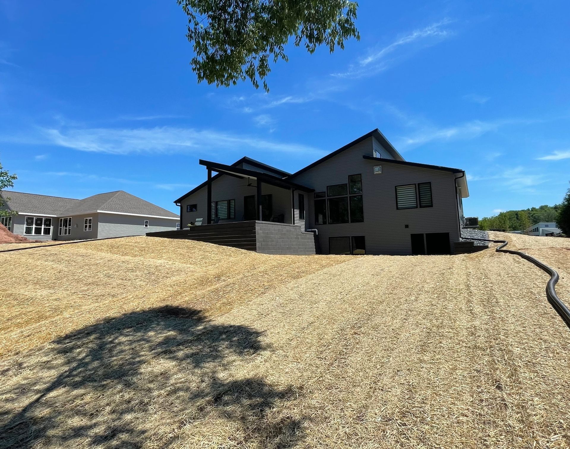 A large house is sitting in the middle of a dirt field.