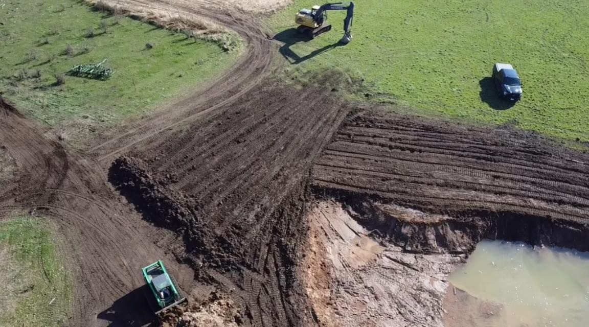 An aerial view of a construction site with a bulldozer and a truck.