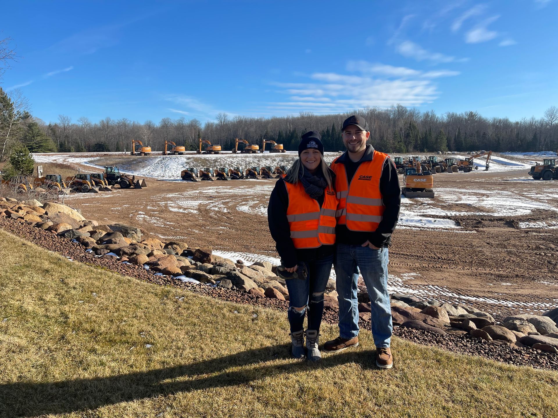 A man and a woman are standing next to each other in a field.