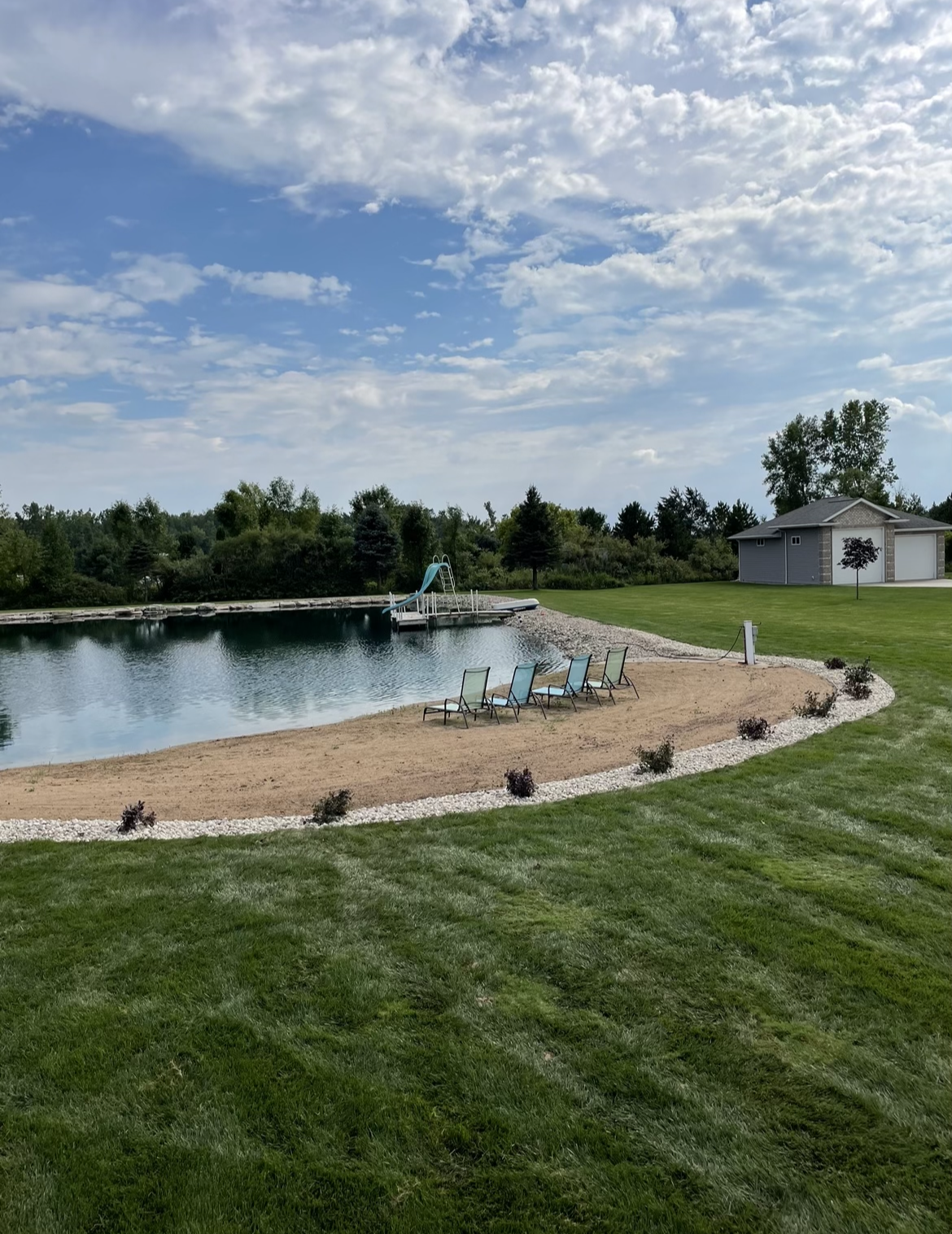 There is a large body of water in the middle of a lush green field.