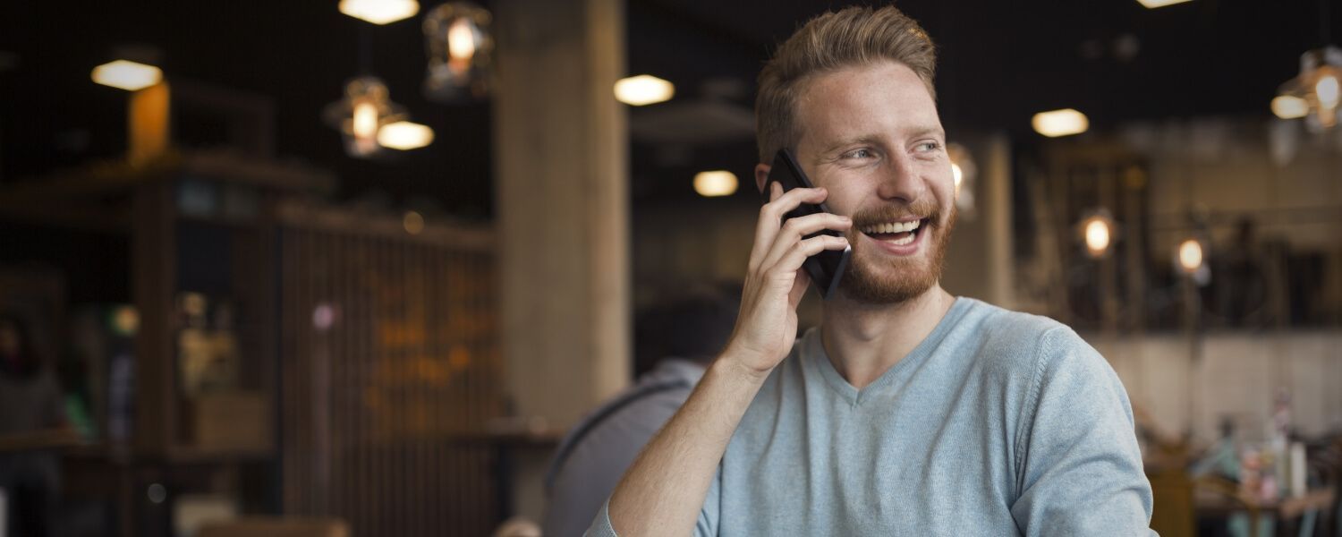 A man is talking on a cell phone in a restaurant.