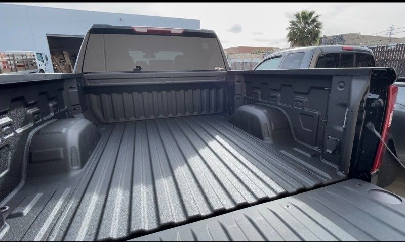The bed of a truck is painted black and is empty.