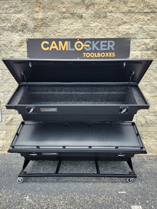 A camlocker toolbox is sitting in front of a brick wall.