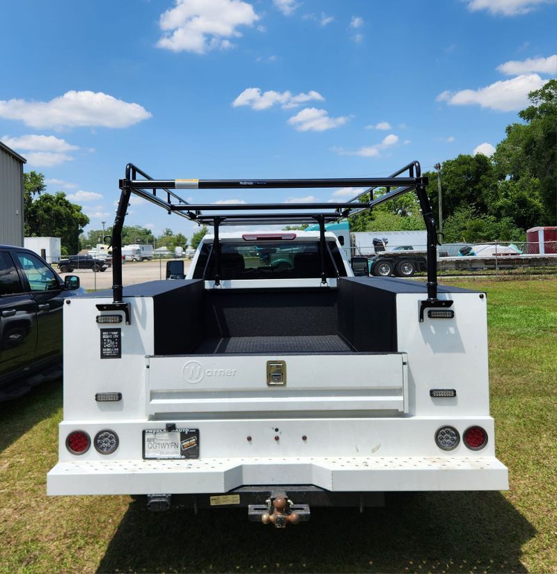 A white truck is parked in a grassy field