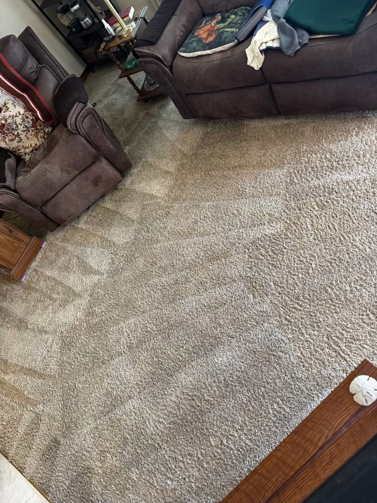 A room with brown reclining chairs and light brown carpet.