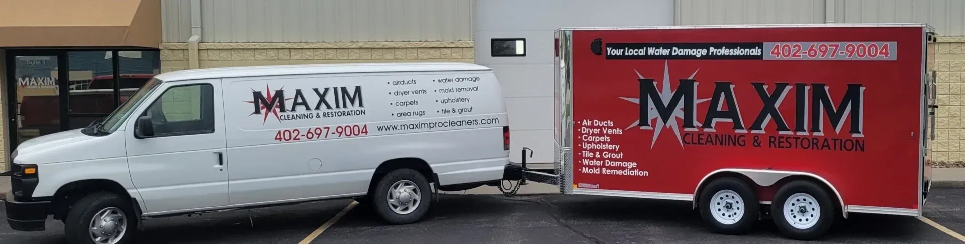 White van towing a red trailer, both with 