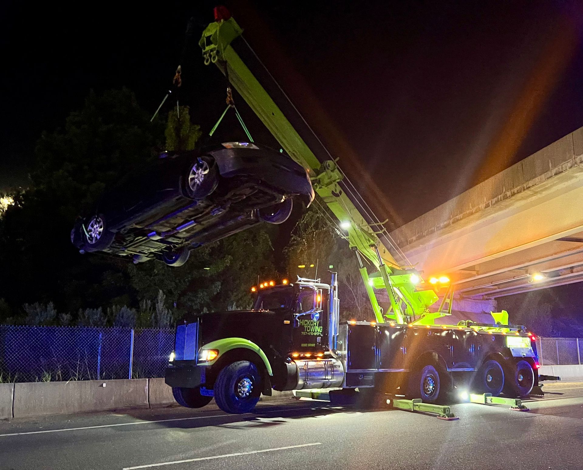 A car is being lifted by a crane on top of a truck.