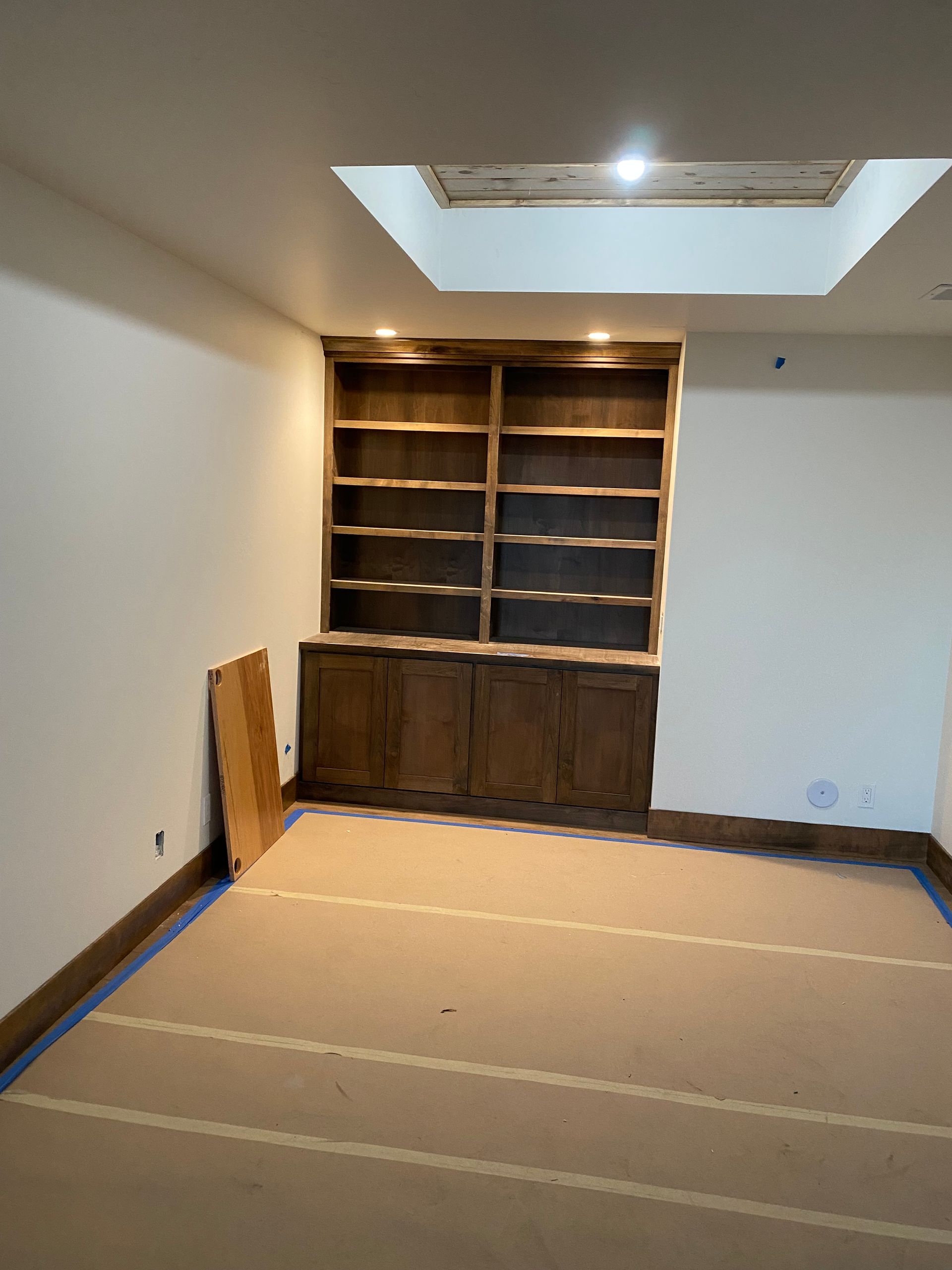 An empty room with shelves and a skylight in the ceiling