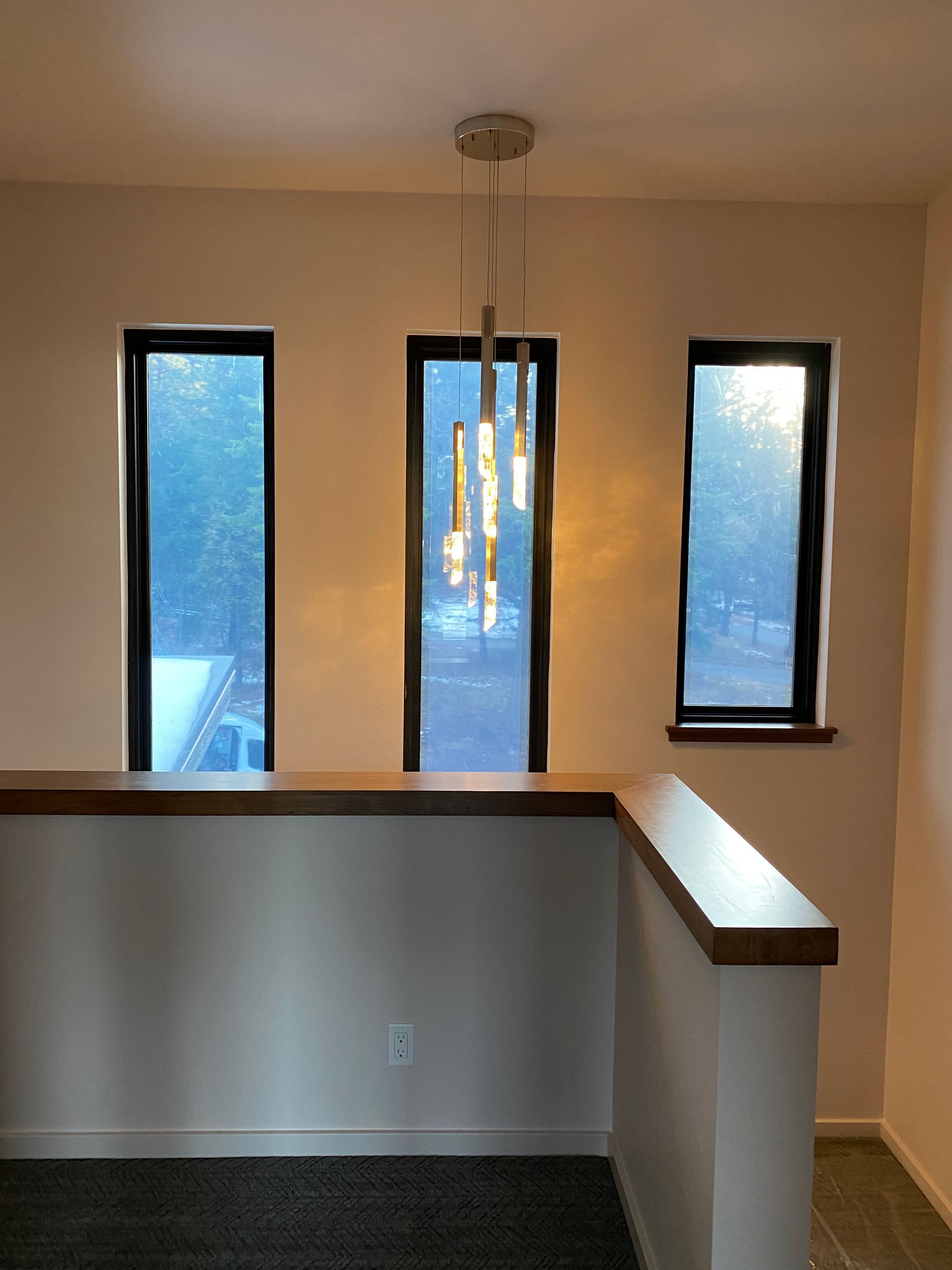 An empty room with three windows and a ceiling light