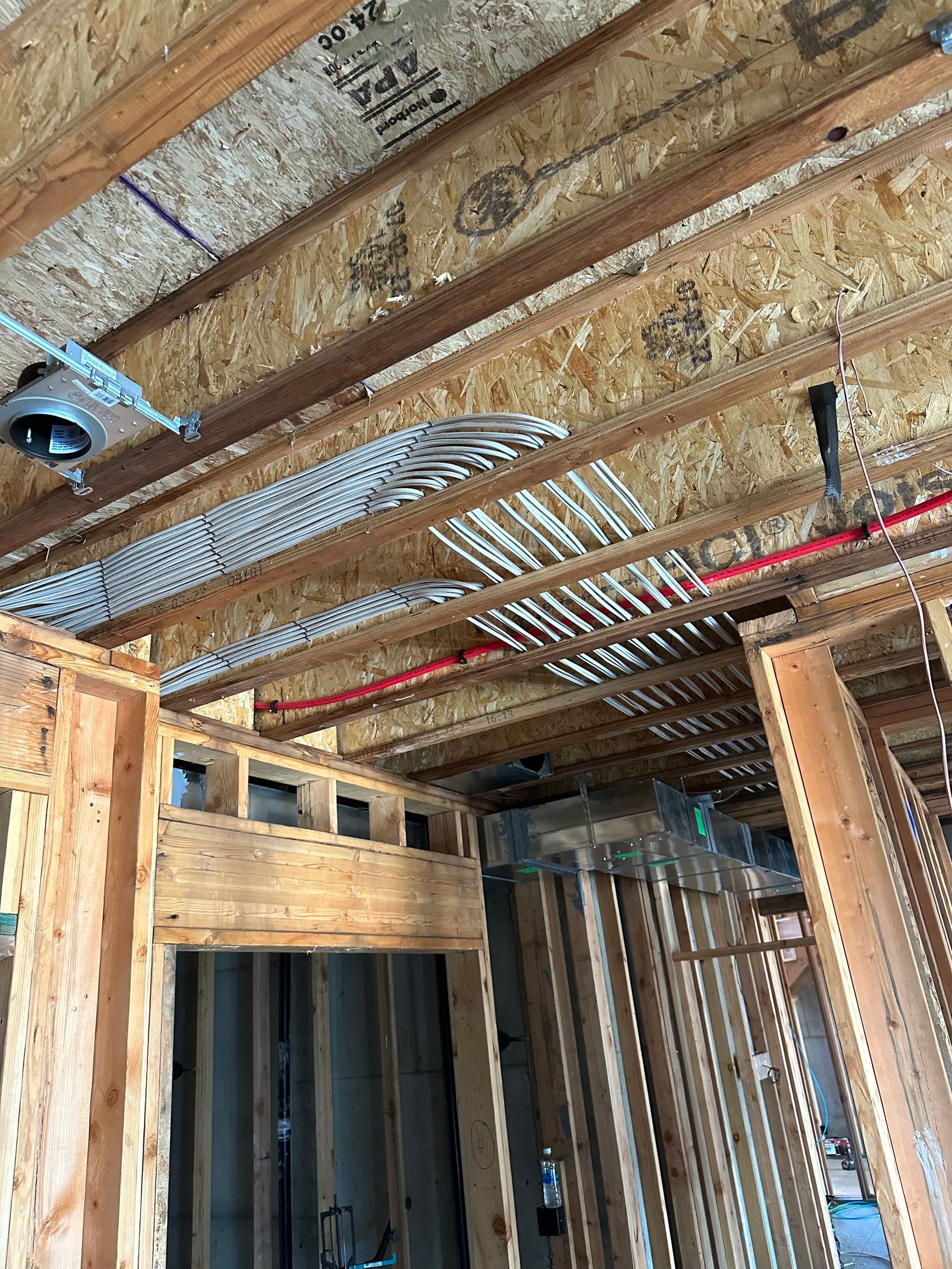 The ceiling of a building under construction with a lot of wooden beams.