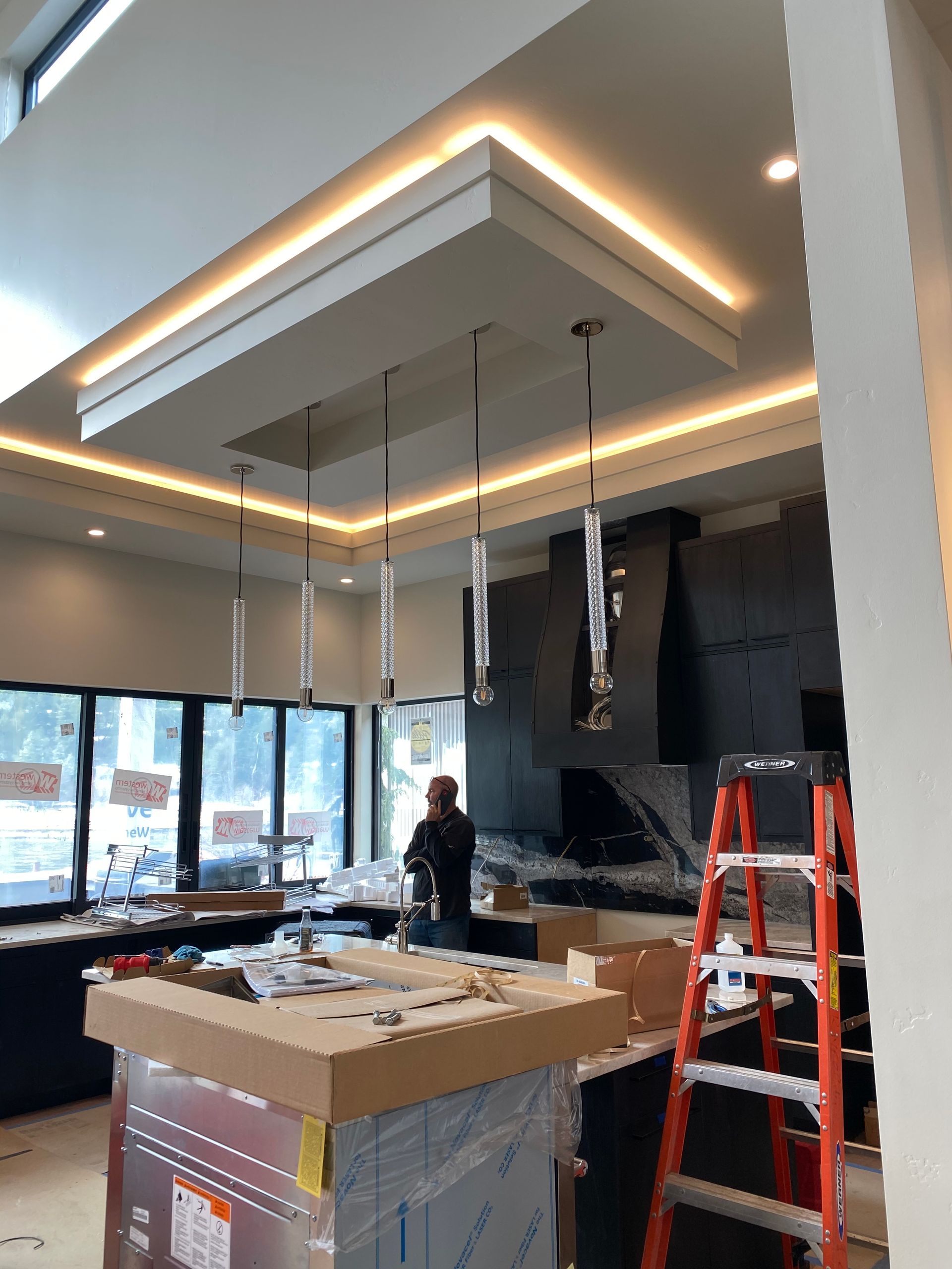 A kitchen under construction with a ladder in the foreground
