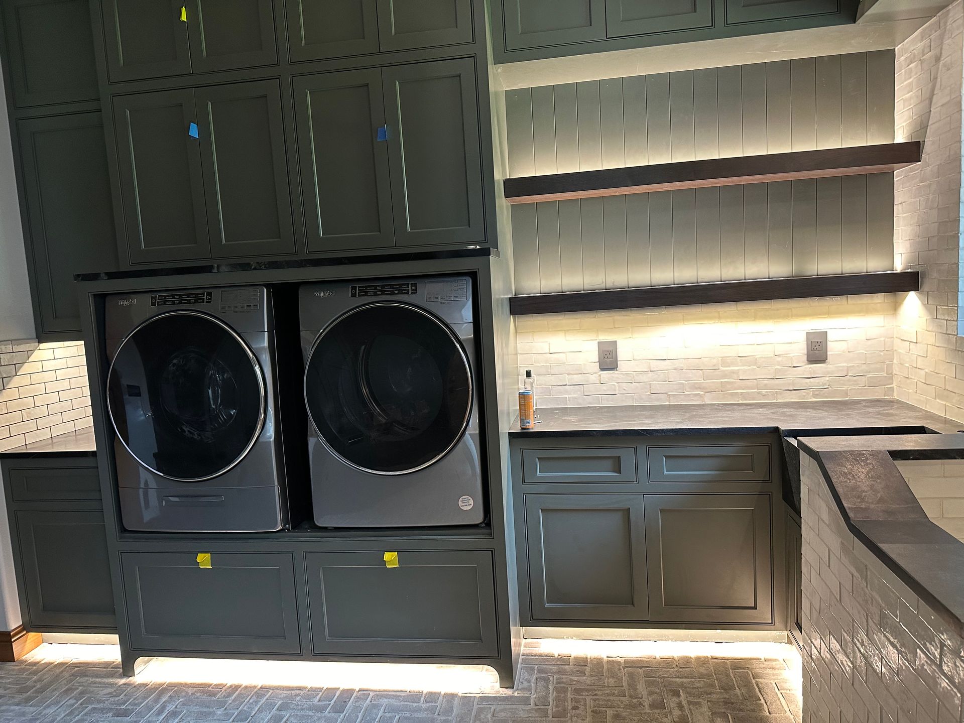 A laundry room with a washer and dryer and a sink.