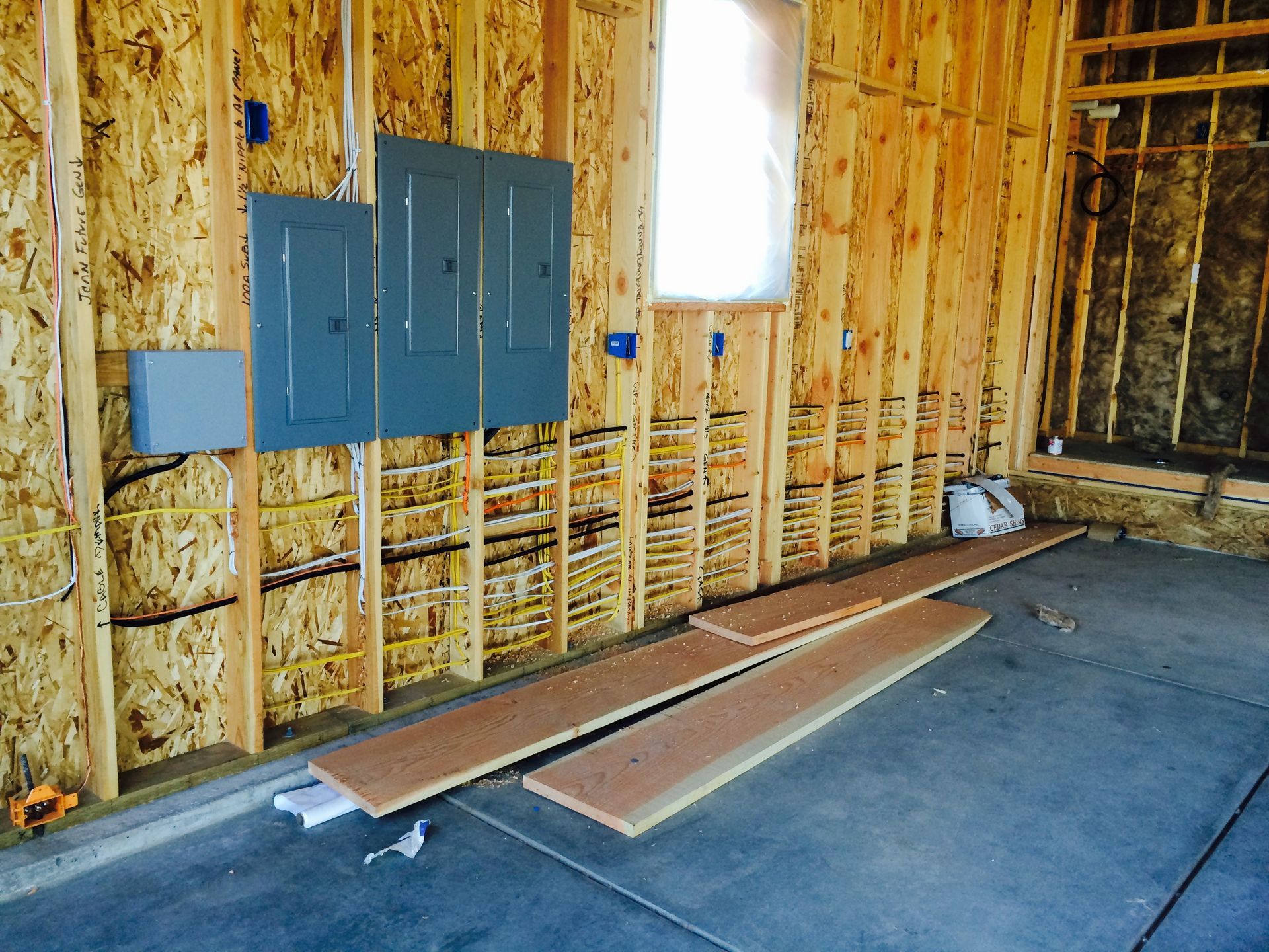 A wooden wall with electrical panels and a window