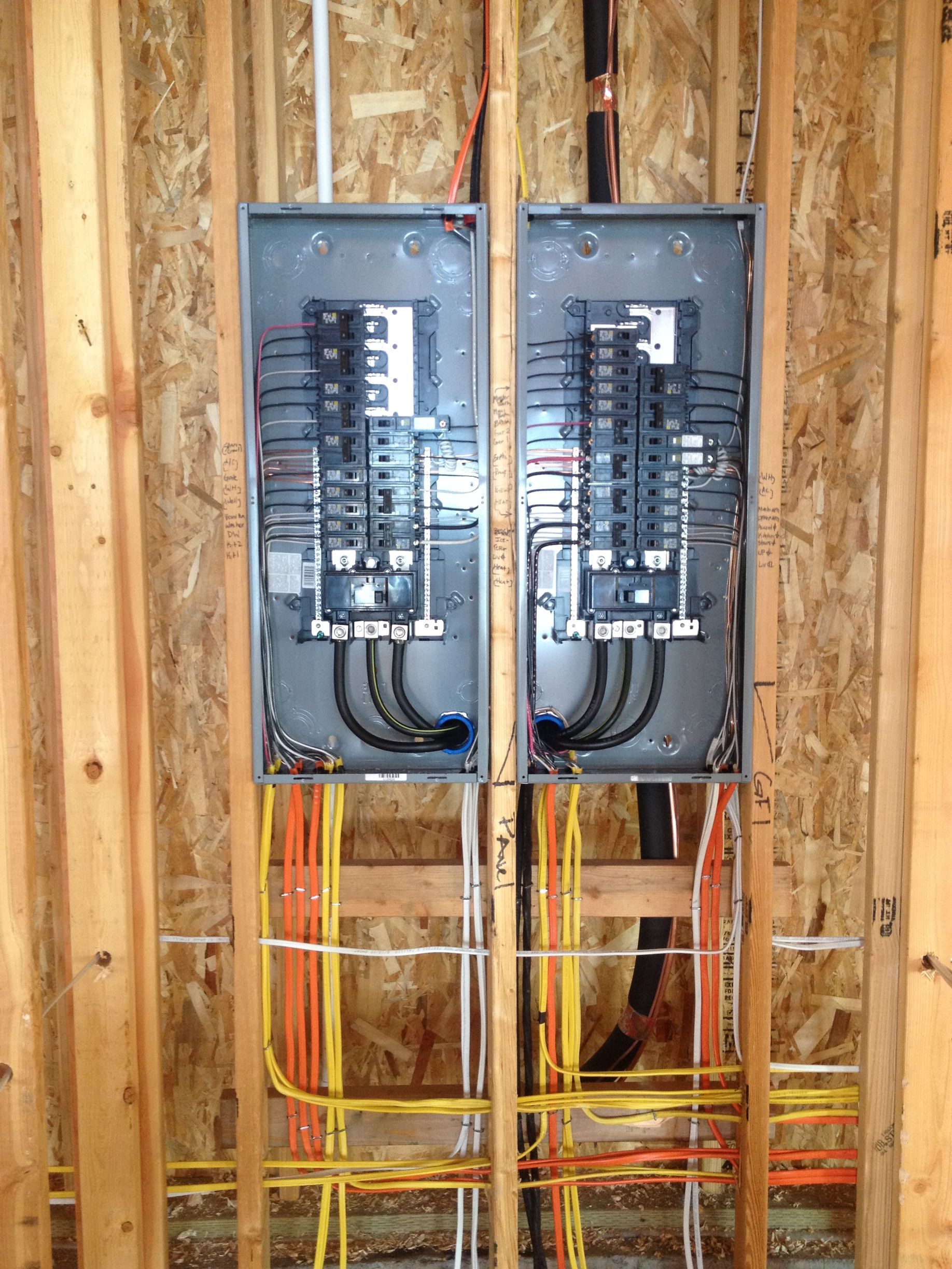 Two electrical panels are installed in a wooden wall
